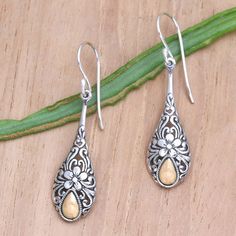 The classic raindrop earring reveals a Balinese touch. Made Suyana crafts the pair with an intricate floral design in sterling silver, using oxidation to highlight the details. He adds a droplet bathed in glowing 18k gold. Silver Drop Pierced Earrings As Gift, Traditional Teardrop Earrings For Gift, Traditional Teardrop Earrings As A Gift, Traditional Sterling Silver Drop Jewelry, Traditional Silver Drop Jewelry, Ornate Teardrop Earrings As Gift, Silver Teardrop Flower Earrings For Pierced Ears, Silver Teardrop Earrings With Oxidized Finish As Gift, Sterling Silver Teardrop Earrings With Intricate Design