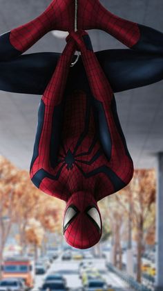 a spider man hanging from the ceiling in front of a parking lot filled with cars