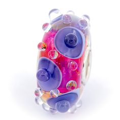 a glass bead with many different colors on it's sides and bubbles around the beads