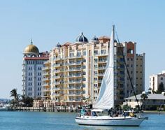 a sailboat in the water next to a large building