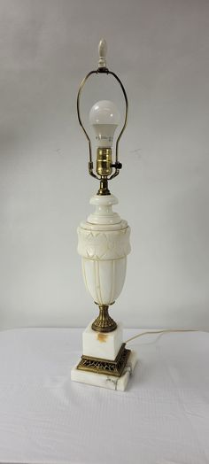 a white and gold lamp sitting on top of a table