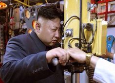 two men working on machinery in a factory