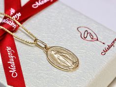 This exquisite Miraculous Medal, made in France, is a stunning piece crafted from solid sterling silver and plated with 3 microns of gold. Available for both men and women, it can be purchased with or without a chain. The medal measures 19 x 13 mm, making it a perfect size for daily wear. The Miraculous Medal is steeped in history and significance. It was originally given to St. Catherine Labouré during her visions of the Blessed Virgin Mary in 1830. The inscriptions on the medal are in French, just as they appeared in the original design. Front of the Medal: The front features an image of the Virgin Mary with the words "O Marie, conçue sans péché, priez pour nous qui avons recours à vous" ("O Mary, conceived without sin, pray for us who have recourse to thee"). This inscription highlights Miraculous Medal Pendant Gift, Yellow Gold Miraculous Medal As Gift, 14k Gold Miraculous Medal As A Gift, 14k Gold Miraculous Medal As Gift, Yellow Gold Miraculous Medal Necklace As Gift, Core Beliefs, St Catherine, Saints Medals, Message Of Hope