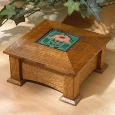 a small wooden box sitting on top of a table next to a potted plant