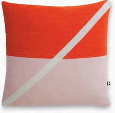 an orange and white pillow with a diagonal stripe on the front, in two different colors