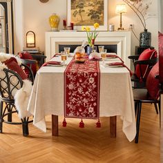 a dining room table is set with red and white linens