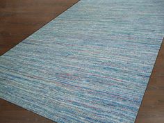 a blue and red rug on top of a wooden floor