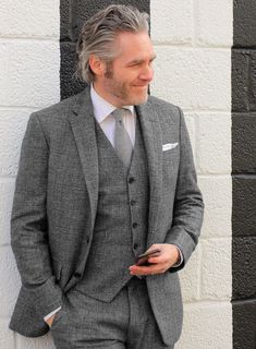 Tailored in a classic gray hue, the Vintage Glasgow Gray Tweed jacket is one of a kind that will hold eternal relevance in any jacket repertoire. Crafted from wool, the famous tweed is hard-wearing and warm and considered as an ideal fabric for dissipating the damp and cold weather. Pair it with a matching waistcoat and trousers, a white shirt, black shoes and a navy silk tie for an elegant formal look. 
 
Look Includes   Vintage Glasgow Gray Tweed Fabric  Two Button Jacket Style  Notch Lapel  S Dark Tweed Suit, Tailored Timeless Tweed Blazer, Timeless Tailored Tweed Blazer, Timeless Tweed Blazer For Business Casual, Timeless Tweed Single-breasted Blazer, Timeless Single-breasted Tweed Blazer, Timeless Tweed Jacket With Welt Pockets, Timeless Long Sleeve Tweed Jacket, Classic Fitted Charcoal Outerwear