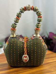 This rare vintage Mary Frances beaded mini bag is a true work of art, featuring exquisite exotic embellishments that make it a one-of-a-kind accessory. Intricately crafted with an array of colorful beads, this stunning bag showcases Mary Frances' signature flair for unique, ornate designs. The exotic embellishments include delicate beadwork, sequins, and intricate patterns that give the bag an eye-catching appeal. Perfect for special occasions or as a collectible, this mini bag is a statement piece that will add a touch of glamour and artistry to your outfit. Its petite size makes it ideal for carrying essentials like lipstick, keys, and cards while exuding elegance and charm. Rare vintage Mary Frances beaded mini bag Features exotic embellishments and intricate beadwork Unique and ornate Unique Handmade Evening Bags, Traditional Green Beaded Bag, Traditional Green Beaded Bags, Beaded Shoulder Bag For Festivals Gift, Bohemian Embellished Shoulder Bag For Gift, Bohemian Embellished Shoulder Bag As Gift, Traditional Embellished Green Bag, Bohemian Handheld Beaded Shoulder Bag, Traditional Beaded Shoulder Bag As Gift