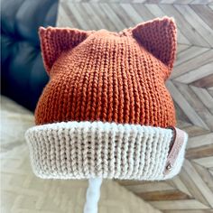 an orange and white knitted hat with ears