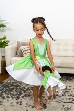 When you twirl in this enchanted green dress, it's as if you're caught in a joyful breeze, and the skirt flutters like the leaves in a magical forest. Designed for twirling - cut from a full circle of fabric which allows it to billow out as your little one spins and dances Gracefully tiered skirt, with three layers of flowing fabric that cascade elegantly Sunshine-hued flower embellishment at the waist for a finishing touch Made from breathable, stretchy, mid-grade soft knit fabrics Accessories Green Fairy Dress For Dress-up, Green Princess Dress For Dress-up, Green Sleeveless Princess Dress, Green Fairy Dress For Spring Dress-up, Spring Princess Style Green Fairy Dress, Princess Style Green Fairy Dress For Spring, Green Princess Dress For Costume Party, Playful Fitted Green Dress, Whimsical Green Fairy Dress For Dress-up