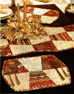 two placemats on a table with silverware and gold candlesticks in the center