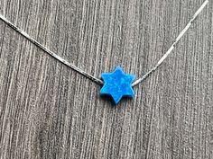 This beautiful Star of David /Magen David/Jewish Star Opal Necklace is sure to be someone's favorite. It's a great Bat Mitzvah or Hanukkah gift. Sterling Silver or 14kt Gold Filled Charm Size: 10mm Lab Created Opal Your Choice of Length and Color Chain Styles: 0.7mm Box Chain Disclaimer: Before placing an order for a necklace or bracelet, please ensure you measure your desired size carefully. Customers are fully responsible for choosing the correct length, as all cut chains are non-refundable. I Blue Star Shaped Necklace For Gift, Blue Necklace With Star Charm As A Gift, Blue Star Charm Necklace As A Gift, Blue Star Charm Necklace As Gift, Blue Star Charm Necklace For Gift, Hanukkah Gift Pendant Jewelry, Blue Sterling Silver Star Of David Necklace, Blue Jewelry With Star Charm For Gifts, Blue Star Charm Jewelry As Gift