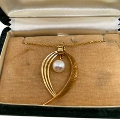 This is part of Chairish’s Fine Jewelry assortment.  A fine vintage, 14K Gold Japanese Mikimoto cultured pearl pendant on chain. The pendant has a Florentine finish on one side and is polished smooth on the other. The pendant has a suspended 6mm beautiful Akoya pearl. The back of the pendant, as well as the clasp, is stamped K14 and the Mikimoto makers mark- M in an oyster shell. The necklace comes in a vintage Mikimoto box. Condition is excellent   Dimensions- Chain Length: 19"; Pendant dimensi Vintage Gold Akoya Pearl Necklace, Formal Vintage Akoya Pearl Necklace, Vintage Akoya Pearl Necklace For Anniversary, Vintage Akoya Pearl Necklace, Heirloom 14k Gold Necklace With Pearl Pendant, Vintage Gold Akoya Pearl Jewelry, Vintage Gold Jewelry With Akoya Pearl, Vintage Akoya Pearl Jewelry For Anniversary, Elegant Pearl Charm Heart Pendant Necklace