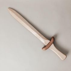 a wooden knife with a wood handle on a gray background