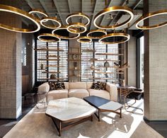 a living room filled with furniture and lots of lights hanging from it's ceiling