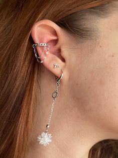 a close up of a person wearing some kind of ear chain with flowers on it