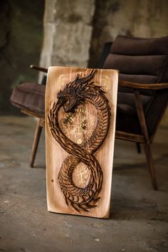 a wooden sculpture with a dragon on it's face in front of a chair