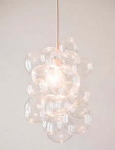 a chandelier hanging from a ceiling in a room with white walls and flooring