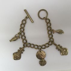 This is: An original vintage charm bracelet from the 60/70s. Lovely heavyweight gold tone brass curb bracelet with egraved ancient instrument, fish, urn and disc charms, fastening with a toggle clasp. Please see pics for size/weight/condition. Condition:  Great, no flaws. Any questions, please message me, thanks. I accept all returns - if you are not happy with your item, please message me before leaving feedback and I will be happy to deal with your concerns. I try my best to be as accurate as possible in my listings, but occasionally I will make a genuine mistake and will rectify it very quickly, just let me know, thanks. Vintage Charm Brass Bracelet, Unique Gold Metal Charm Bracelet, Gold-tone Brass Charm Bracelet With Lobster Clasp, Gold Engraved Metal Charm Bracelet, Engraved Gold Metal Charm Bracelet, Adjustable Brass Charm Bracelet, Bohemian Gold Charm Bracelet With Lobster Clasp, Gold Bohemian Charm Bracelet With Lobster Clasp, Bohemian Gold Charm Bracelet In Brass