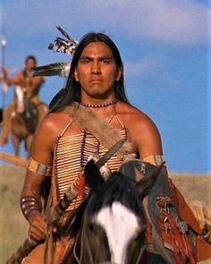 a native american man riding on the back of a horse