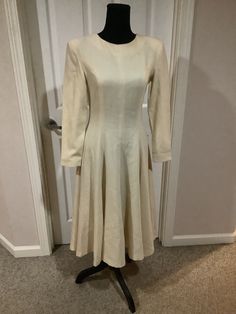 This nice vintage Vogue 50s 60s cream bone Pollyanna padded shoulder full romantic dress with huge bow in back comes to you in a size S-M. As you can see nice vintage cond. there are a couple of tiny pin prick holes one up by shoulder pictured and one on sleeve. Pretty typical age. Timeless flattering style. Waist is 14 inches across-21 1/2 inches shoulder to bottom of arm. 43 inches shoulder to bottom of dress. Full skirt style. Very figure flattering Elegant A-line Midi Dress For Vintage Fashion, Cream A-line Winter Dress, Elegant Beige A-line Vintage Dress, Classic A-line Vintage Wedding Dress, Classic Beige Winter Dresses, Classic Vintage A-line Dress With Fitted Bodice, Elegant A-line Vintage Winter Dress, Classic A-line Dress For Vintage Fashion, Classic Fitted A-line Vintage Dress