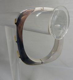 "Here's a stylishly modern hinged bangle bracelet, made in sterling silver and signed with Juan Sandoval Vazquez's Two Trees logo. It has gold vermeil accents on the front in a diagonal pattern, Interior circumference is 6.3/4\" and it is 3/8\" wide. It weighs 42 grams and is fully hallmarked. It is in exceptional pre-owned condition with no scratches or damage. Thanks for looking." Contemporary Formal Cuff Bracelet Bangle, Modern Sterling Silver Cuff Bracelet For Anniversary, Modern Metal Bracelets For Anniversary, Modern Polished Cuff Bracelet For Anniversary, Modern Polished Sterling Silver Bracelet, Modern Sterling Silver Bracelet For Formal Occasions, Formal Modern Sterling Silver Bracelet, Modern Metal Bangle With Polished Finish, Modern Silver Bangle For Formal Occasions