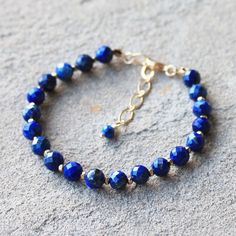 This gorgeous dark blue Lapis Lazuli gemstone bracelet features 18K gold filled accents. Stone: Lapis Lazuli Colour: Dark Blue Main Stone Size: 6mm round  Metal: 18K Gold Filled or Solid 925 Sterling Silver  Length: 19 - 24cm (with extension chain) I love making beautiful, handmade one-of-a-kind pieces of jewellery using semi-precious natural stones and crystals that can be treasured for a lifetime. I can customise a design specifically to meet your needs with your favourite semi-precious stones Elegant Lapis Lazuli Gemstone Bracelets, Sapphire Lapis Lazuli Bracelets With Round Beads, Elegant Blue Hand-strung Crystal Bracelet, Elegant Handmade Lapis Lazuli Bracelets, Gold Bracelets With Lapis Lazuli And Natural Stones, Sapphire Gemstone Beads Bracelet In Lapis Lazuli, Blue Lapis Lazuli Gemstone Beaded Bracelet, Gold Beaded Lapis Lazuli Bracelets, Sapphire Lapis Lazuli Beaded Bracelets