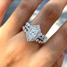 a woman's hand with a diamond ring on top of her finger and an engagement band