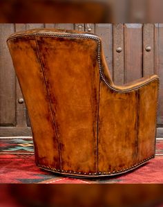 a brown leather chair sitting on top of a rug