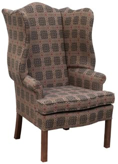 an upholstered wing chair with patterned fabric on the back and footrests