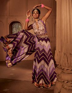 Make a style statement like a traditional diva in this alluring sharara set featuring geometrical print sharara coordinated with an intricately embroidered blouse with a stylised back design with heavy tassels and doris. Purple Palazzo Set With Zari Work For Navratri, Purple Sharara For Transitional Season, Purple Anarkali Palazzo Set With Cutdana, Georgette Palazzo Set With Printed Motifs For Reception, Semi-stitched Georgette Lehenga With Printed Motifs, Floor-length Georgette Palazzo Set With Pallu, Floor-length Georgette Lehenga With Printed Motifs, Designer Floor-length Palazzo Set For Navratri, Semi-stitched Sharara With Pallu