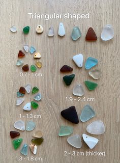 the different shapes and sizes of sea glass are shown on a wooden table with measurements