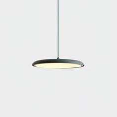 a light that is hanging from the ceiling in a room with white walls and flooring