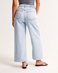 Our Curve Love high rise cropped wide leg jeans in a light wash with a raw-cut hem. This fit features a 10.5” high rise, is relaxed at the waist and hips, and eases into a wide, full-length leg shape with a cropped length. Our Curve Love styles add an additional 2” at the hip and thigh to allow room for your curves and eliminate waist gap. This jean is made from our super light drapey denim fabric, which features a super soft lightweight rigid denim. Light Wash Flare Jeans With Frayed Hem For Spring, Spring Cropped Jeans With Frayed Hem, Cropped Medium Wash Bottoms With Frayed Hem, Light Wash Cropped Bottoms For Everyday, Everyday Light Wash Cropped Bottoms, Light Wash Cropped Jeans For Everyday, Everyday Light Wash Cropped Jeans, Light Wash Cropped Jeans With Five Pockets, Trendy Light Wash Wide Leg Cropped Jeans