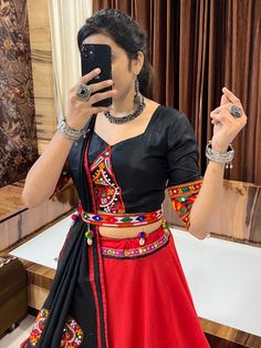 Embrace the vibrant Navratri festival vibes with our stunning Red & Black Gamthi Work Cotton Navratri Lehenga Choli. This eye-catching ensemble is perfect for celebrating the festive season with style and grace.
The Lehenga Choli features a black choli, a red lehenga, and a black dupatta. Each piece is intricately adorned with multi-colored Gamthi work butta, lace, and mirror work, adding a touch of elegance and sophistication to the outfit. The use of comfortable cotton silk for the lehenga Black Dress With Mirror Work For Navratri, Red Bohemian Anarkali Set For Navratri, Black Sharara For Festive Navratri, Black Sharara For Festive Navratri Occasions, Black Cutdana Sharara For Navratri, Black Traditional Wear With Mirror Work For Navratri, Black Cutdana Lehenga For Festivals, Bohemian Red Sets With Unstitched Blouse, Traditional Black Choli With Mirror Work