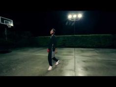 a man standing on top of a basketball court at night