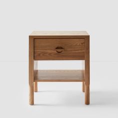 the side table is made out of wood and has an open drawer on one side