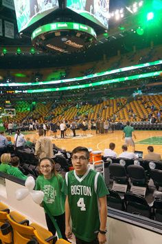 two people in green shirts at a basketball game