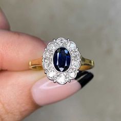 This item has just been reserved by another customer. Please contact us to be notified if it becomes available.  This beautiful vintage cluster ring showcases a genuine bezel-set central sapphire weighing around approx 0.50 carats. Surrounding the gemstone are several old Europan-cut diamonds, collectively weighing approx 0.60 carats. Crafted during the Edwardian era around 1900, this ring is fashioned from 18k yellow gold.  ✦ GEMSTONE SPECIFICATIONS: Center Gemstone: Sapphire  Sapphire Weight: Timeless Oval Sapphire Ring Vvs Clarity, Timeless Oval Sapphire Ring With Vvs Clarity, Classic Oval Sapphire Ring With Rose Cut Diamonds, Oval Sapphire Ring With Rose Cut Diamonds, Oval Cabochon Sapphire Ring With Center Stone, Vintage Oval Sapphire Ring Vvs Clarity, Exquisite Oval Sapphire Ring With Vvs Clarity, Heirloom Oval Sapphire Ring With Prong Setting, Oval Cluster Ring With Gemstone In Platinum