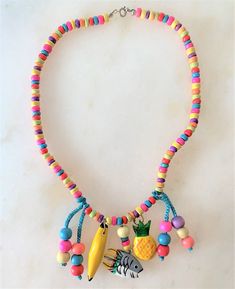 "Kids 15\" Brite Multi Colored Coco Beads Necklace with Hand Painted Wooden Charms & Beads Brite Multi Coco Chips Necklace Hand Painted Wooden Fish, Pineapple & Banana Charms Turquoise Cord with Multi Colored Wooden Beads Wooden Charms Hang Approx 1 1/2\" Long Silver Tone Spring Ring Clasp Made in the Philippines COMPLIMENTARY DOMESTIC SHIPPING" Adjustable Whimsical Beaded Necklaces, Fun Beaded Adjustable Necklace, Fun Beaded Adjustable Necklaces, Adjustable Playful Beaded Necklaces For Festivals, Adjustable Playful Beaded Necklace For Festival, Fun Adjustable Beaded Necklaces, Playful Beaded Necklaces For Festivals, Playful Adjustable Necklaces For The Beach, Whimsical Adjustable Necklace With Colorful Beads