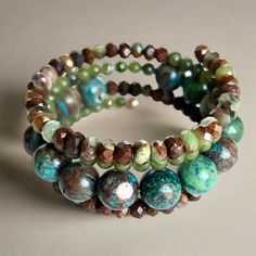 Shades of green, blue, and brown dominate this beaded coil wrap bracelet. Faceted chrysoprase, round jade, and African turquoise come together in a medley of tone and texture in this done-for-you stack. I love the earth tones and contrast of size, color, and texture in this one-of-a-kind bracelet. 4mm round jade 4x5mm faceted chrysoprase 10mm African turqouise one size fits most - best for small to medium wrists Handmade in Lincoln, Nebraska Turquoise Agate Bohemian Bracelets, Bohemian Turquoise Agate Bracelets, Earthy Turquoise Beaded Bracelets With Gemstone Beads, Artisan Hand Wrapped Wrap Bracelet With Round Beads, Bohemian Jade Bracelets, Handmade Bohemian Jade Bracelets, Green Bohemian Wrap Bracelet With Round Beads, Bohemian Green Wrap Bracelet With Round Beads, Artisan Green Handmade Bracelets