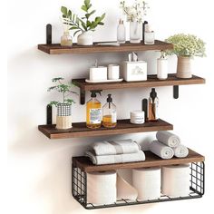 three shelves with towels, soaps and other bathroom items on them against a white wall