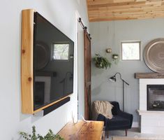 a flat screen tv mounted to the side of a wall next to a fire place