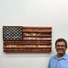 a man is standing in front of an american flag made out of candles and other items