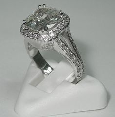 an engagement ring with a large diamond in the center on top of a white stand