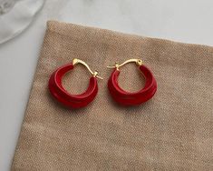 Add some whimsy to your look with these enamel chunky hoops. Perfect for daily wear and plated with 14k gold vermeil, these wavy hoop earrings come in a playful array of white, green, red, black, and brown. About 23mm in diameter, they're dainty yet elegant, making them the perfect accessory for any occasion. Red Enamel Hoop Earrings Gift, Red Enamel Hoop Earrings For Gifts, Trendy Red Hoop Earrings, Trendy Small Red Hoop Earrings, Trendy Small Hoop Red Earrings, Small Hoop Red Earrings For Everyday, Trendy Red Enamel Earrings, Red Enamel Trendy Earrings, Red Small Hoop Earrings For Everyday