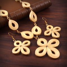 four wooden earrings on a table next to a book