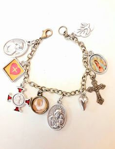 This is a fun and beautiful bracelet to help your devotional life and share the faith with others who see you wearing it. Great for Confirmation or that special mom. A beautiful gift for the Catholic lady on your list. Includes a St Benedict medal/cross, St Joseph medal, Holy Spirit Dove (made by me), Guadalupe charm (made by me), tiny heart, Holy Spirit medal, Jesus in my Heart charm (made by me), and a crucifix, all on a simple chain bracelet, brass tone base metal. Lobster clasp, choice of le Silver Spiritual Rosary Bracelet For Blessing, Spiritual Bracelets With Miraculous Medal As Gift, Spiritual Charm Bracelet Gift, Nickel Free Cross Bracelet With Spiritual Style, Nickel-free Cross Bracelet For Spiritual Style, Spiritual Cross Charm Bracelet Gift, Nickel-free Spiritual Rosary Bracelet Gift, Spiritual Hypoallergenic Charm Bracelet As Gift, Hypoallergenic Spiritual Charm Bracelet As Gift