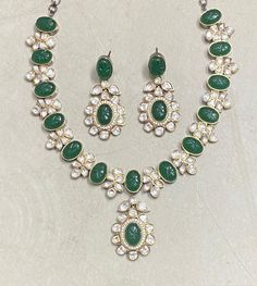 Polki Necklace Set features emerald green Kundan stones with a Sabyasachi-inspired design. Adorned with moissanite and Polki diamonds, it showcases intricate craftsmanship and elegant statement-making. Perfect for weddings, this piece blends traditional Indian artistry with contemporary sparkle, offering a stunning focal point for any bridal ensemble. *𝐏𝐑𝐎𝐃𝐔𝐂𝐓 𝐃𝐄𝐓𝐀𝐈𝐋* * Material: Brass * Plating: Gold Plated * Stone: Semi Precious Kundan & Polki. *𝐃𝐈𝐌𝐄𝐍𝐒𝐈𝐎𝐍𝐒* *  Necklace- Festive Kundan Emerald Necklace For Receptions, Green Oval Necklace For Wedding, Festive Hand-set Emerald Necklace For Wedding, Oval Green Emerald Wedding Necklace, Traditional Hand Set Emerald Necklace For Reception, Elegant Green Meenakari Bridal Necklace, Kundan Emerald Necklace For Wedding, Traditional Kundan Emerald Necklace For Reception, Green Necklace With Intricate Design For Wedding